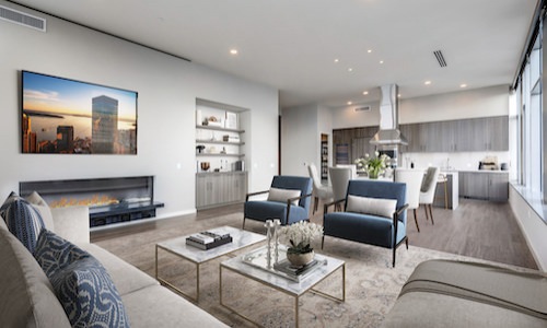 Spacious and well lit living room with wood floors and large windows 