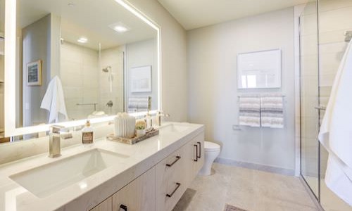 Large well lit bathroom with white accents 