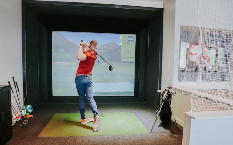 Golf simulator lounge includes additional games like baseball, football and more.